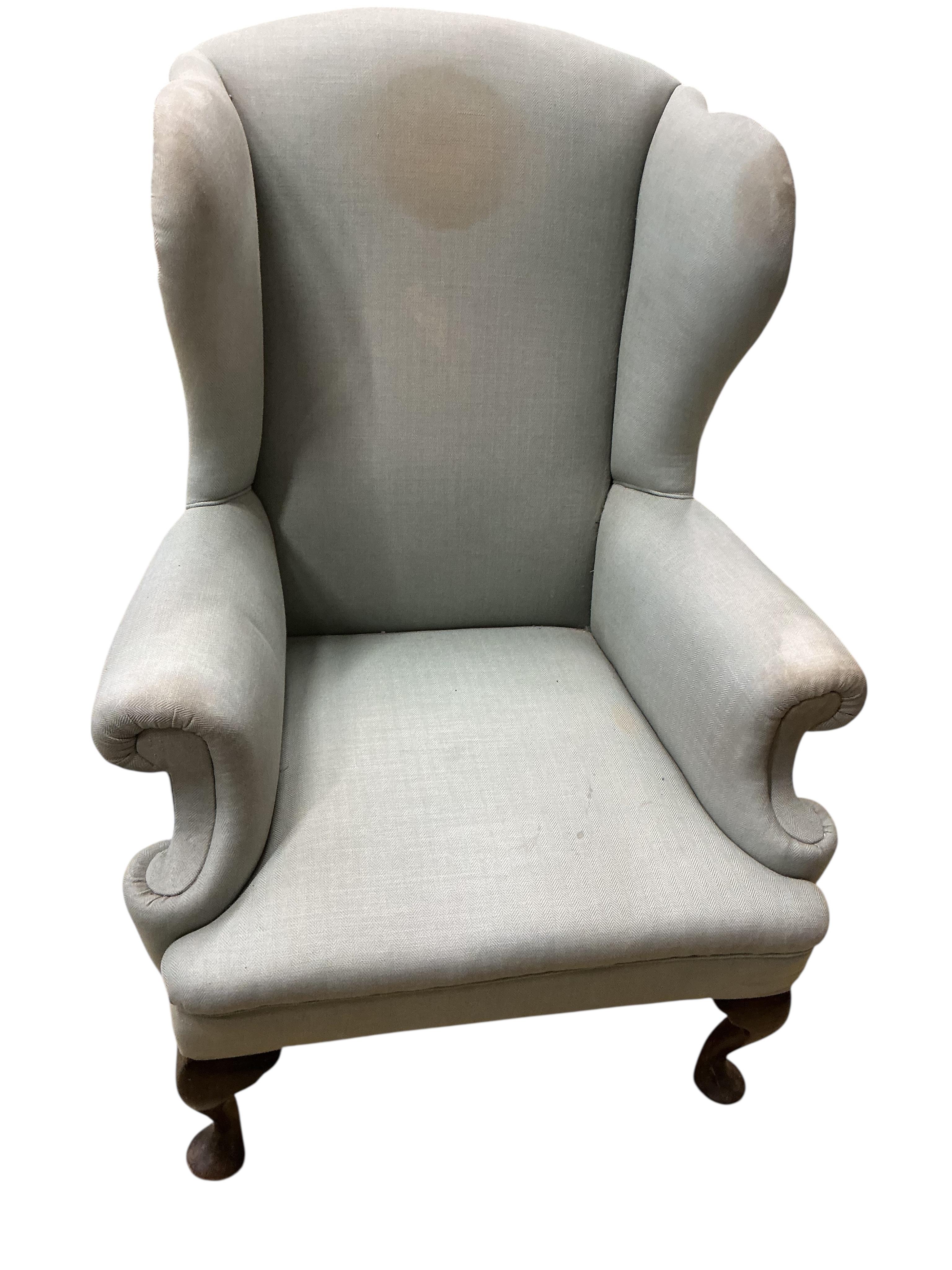 An early 20th century upholstered wing armchair, width 82cm, depth 66cm, height 108cm